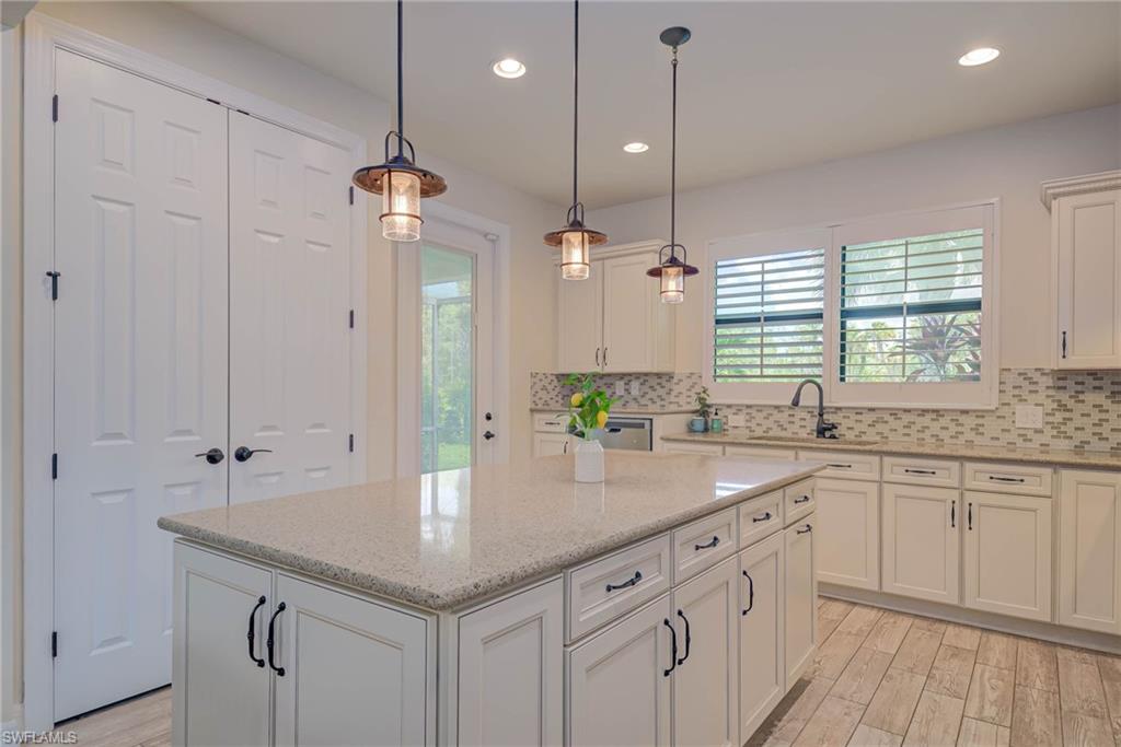 5761 Mayflower Way Ave Maria, FL 34142 - Photo 9 of 39 a kitchen with sink cabinets and chandelier
