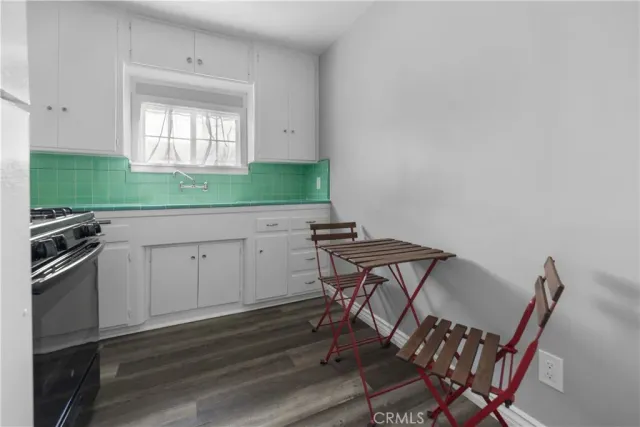 a view of a kitchen with cabinets and wooden floor