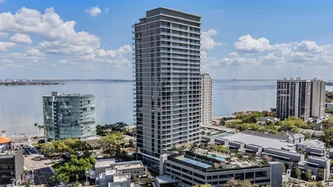 a kitchen with stainless steel appliances granite countertop a sink a stove a refrigerator and island with wooden floor