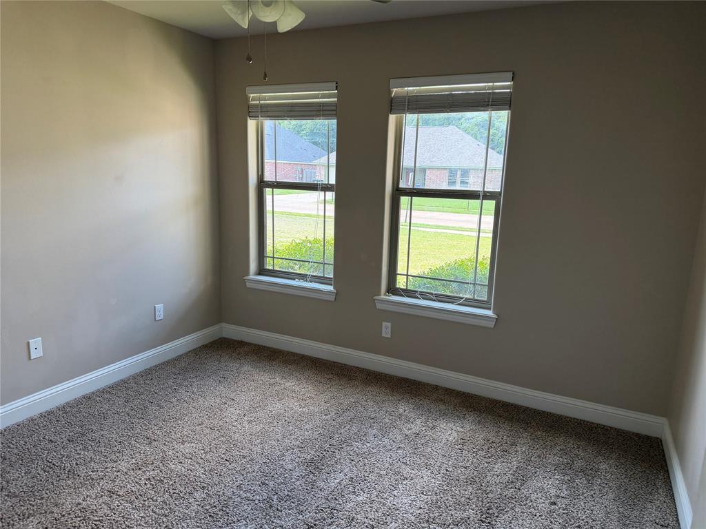520 Big Red Circle Haughton, LA 71037 - Photo 15 of 25 Carpeted interior space featuring two windows with horizontal blinds, neutral wall tones, and white baseboards