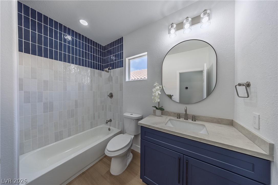 10982 Village Ridge Lane Las Vegas, NV 89135 - Photo 12 of 12 Vibrant blue tile accents complement the clean lines of this modern bathroom, featuring a sleek vanity and ample light.