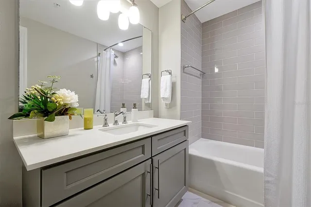 a bathroom with a sink a bathtub a mirror and a shower