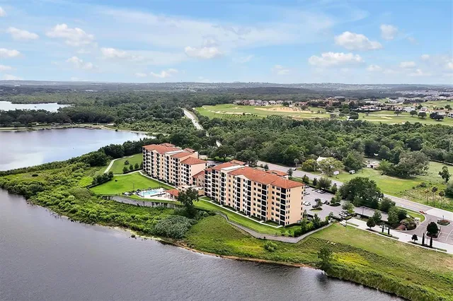 an aerial view of a house with a garden and lake view