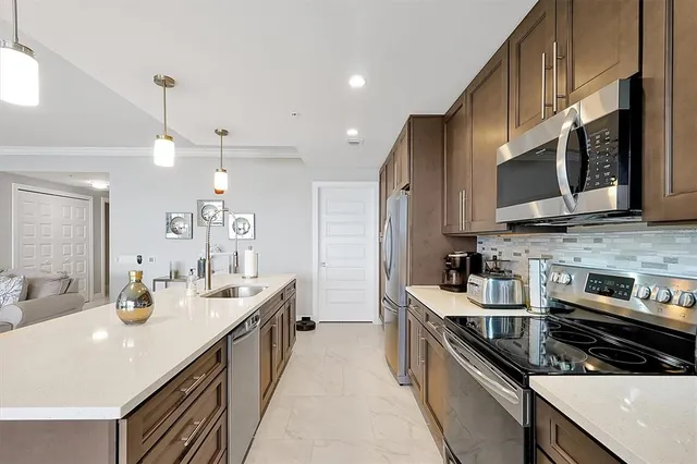 a kitchen with stainless steel appliances a sink stove and microwave