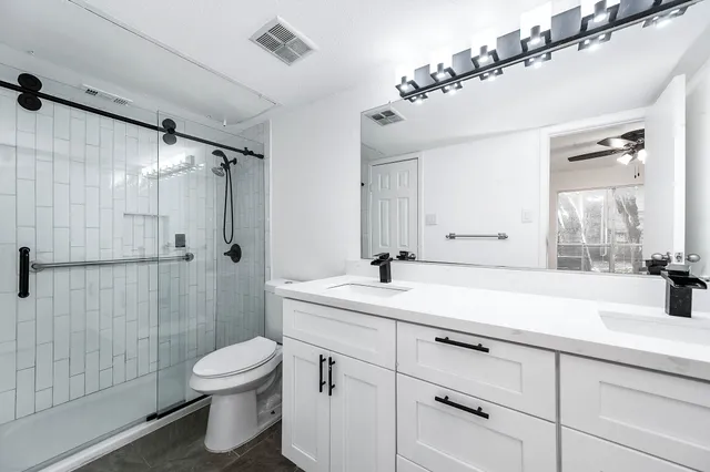 a bathroom with a sink a toilet and shower