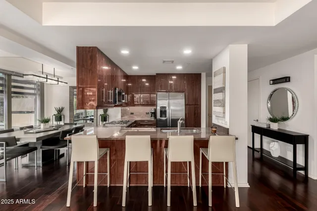 a kitchen with stainless steel appliances granite countertop a stove a sink a dining table and chairs