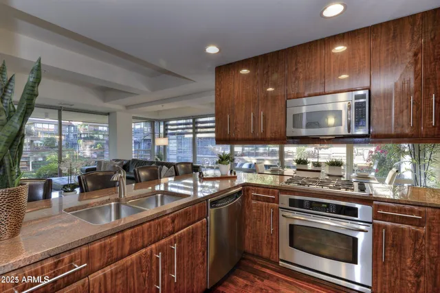 a kitchen with stainless steel appliances a stove sink microwave and cabinets