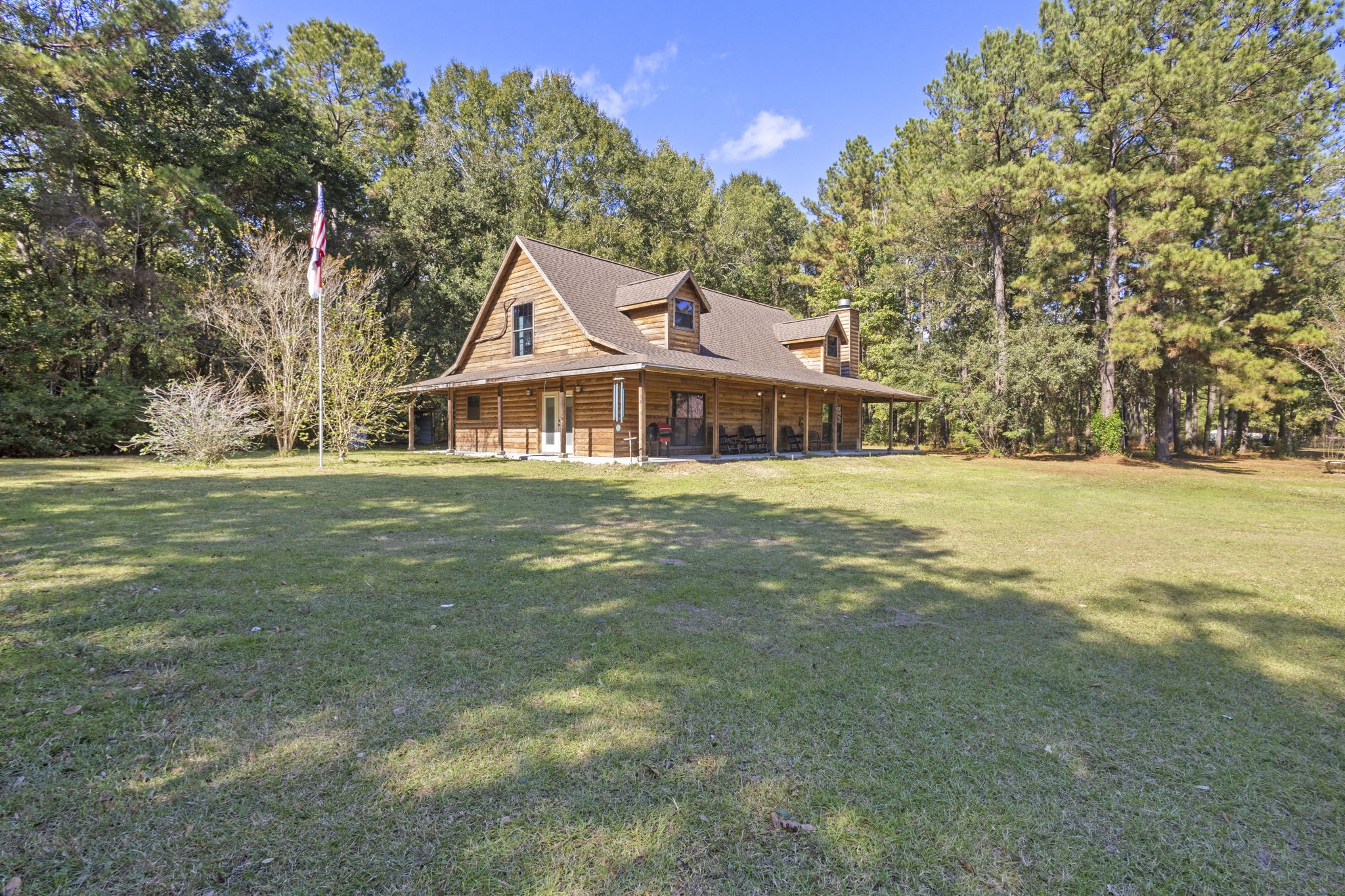 a view of a house with a big yard and large trees