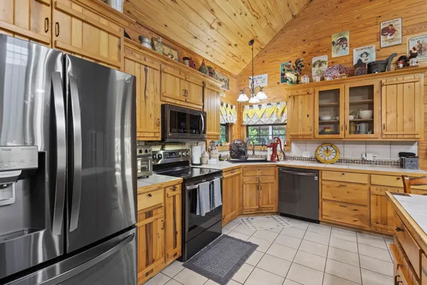 a kitchen with stainless steel appliances granite countertop a refrigerator a stove top oven and sink