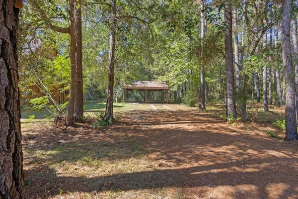 a view of a house with backyard and trees
