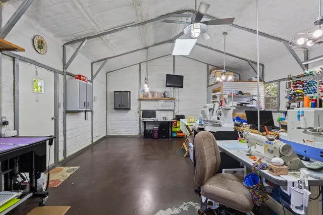 a spacious bedroom with a bed a flat screen tv and a chandelier