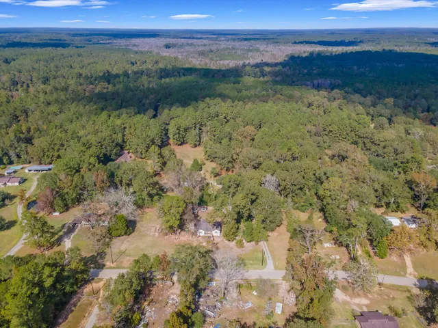 a spacious bedroom with a bed a flat screen tv and a chandelier