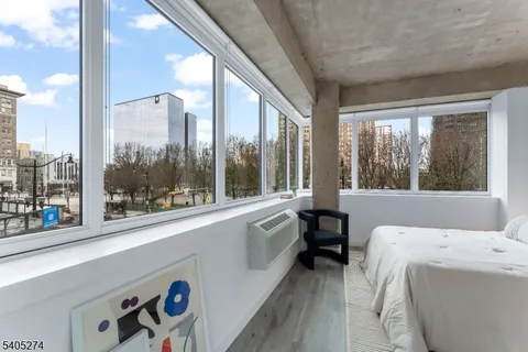 a living room with a large window and a bed