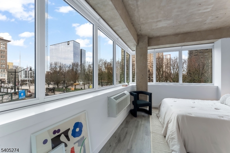 10 Commerce Court, Unit 5G Newark, NJ 07102 - Photo 8 of 11 a living room with a large window and a bed