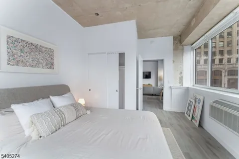 a bedroom with a bed and a large window
