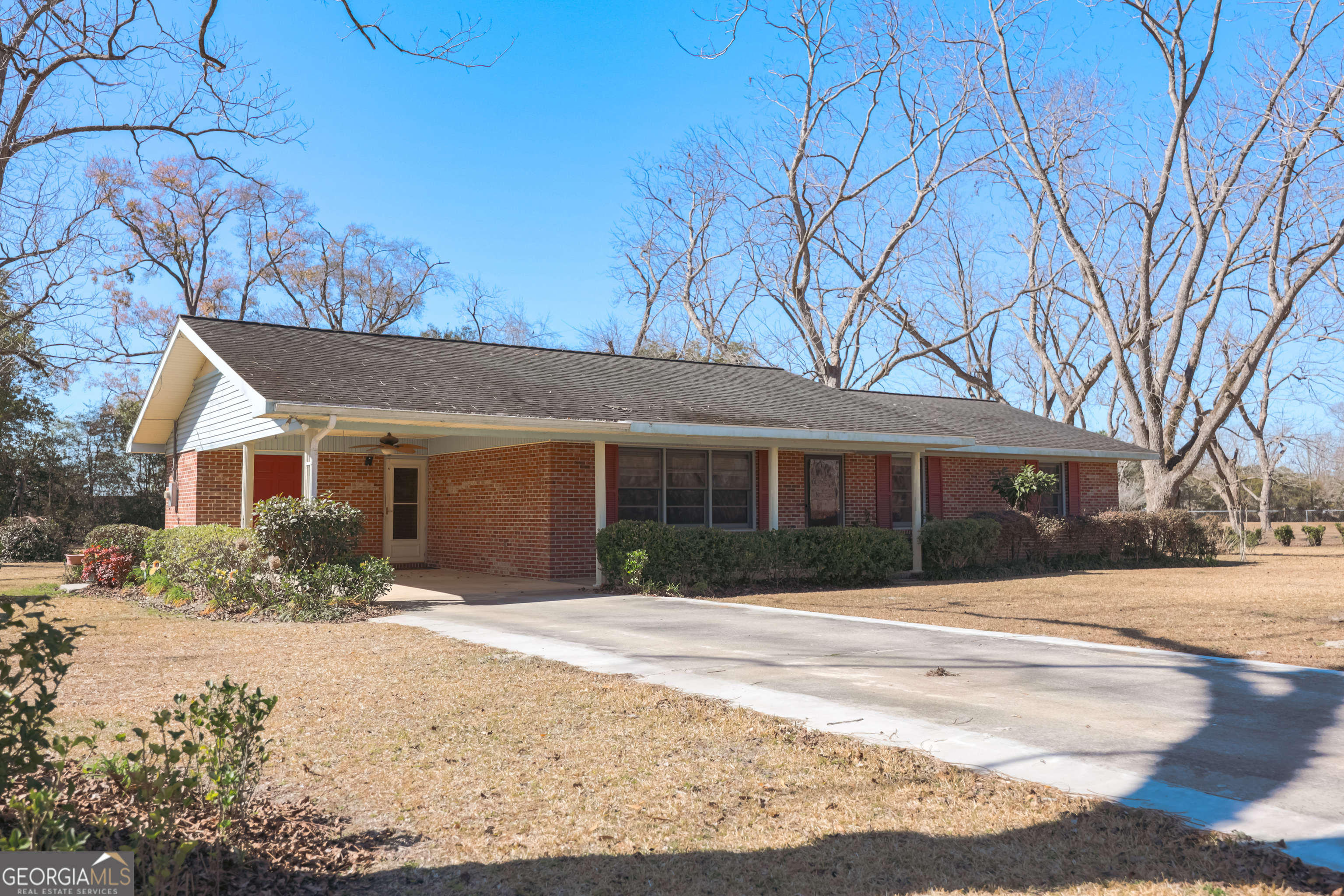 a front view of house with yard and trees around