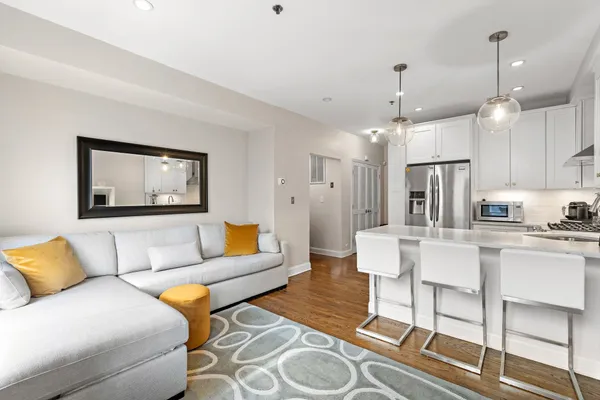 a living room with furniture kitchen and a chandelier
