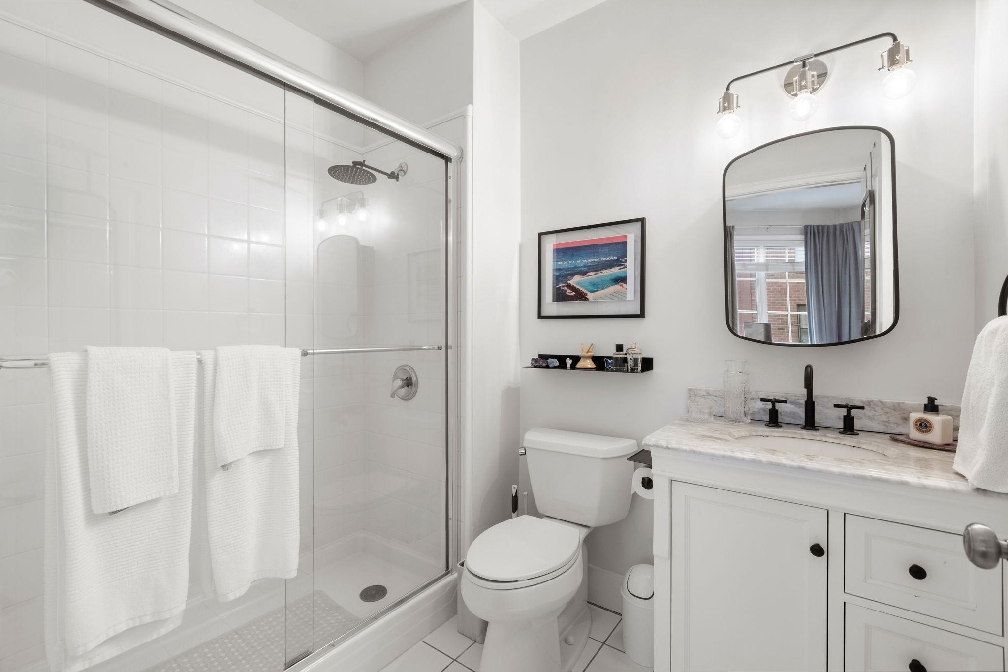 501 9th Street, Unit 309 Hoboken, NJ 07030 - Photo 14 of 18 a bathroom with a toilet sink and shower