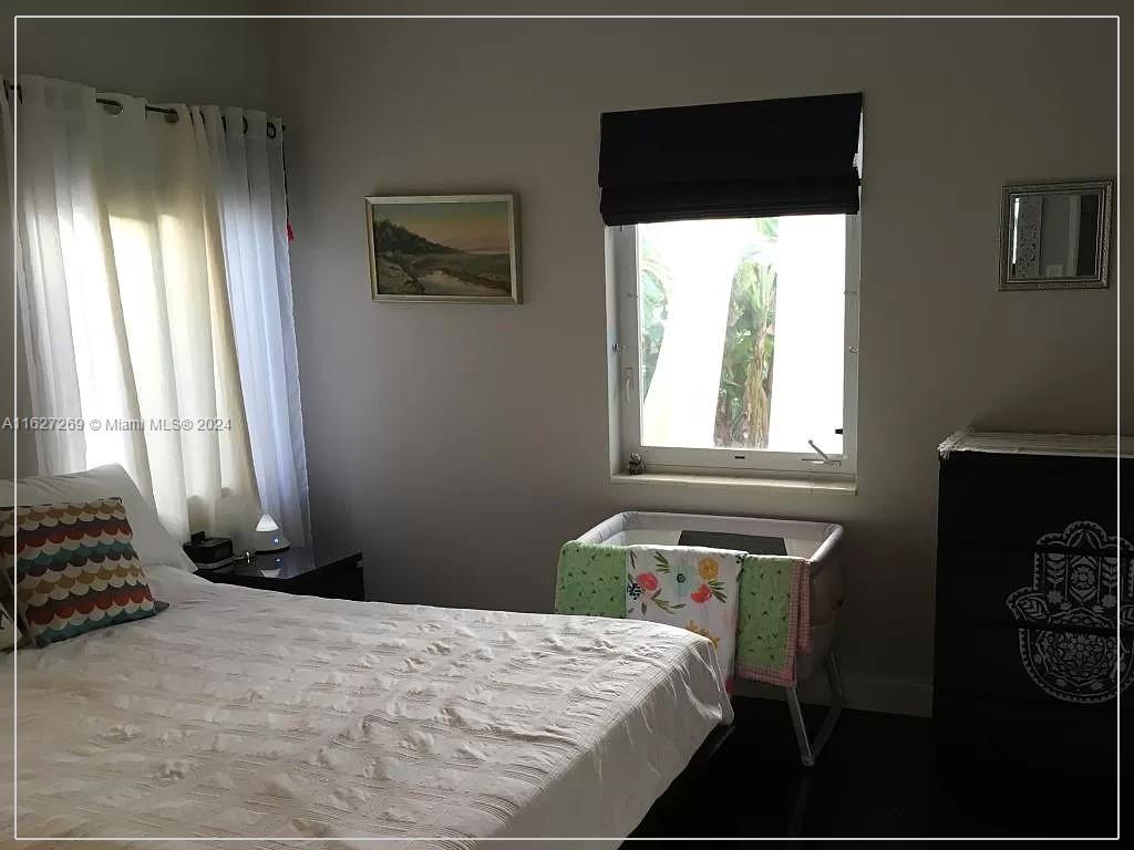 8818 Abbott Avenue Surfside, FL 33154 - Photo 16 of 28 a bedroom with a bed and a window