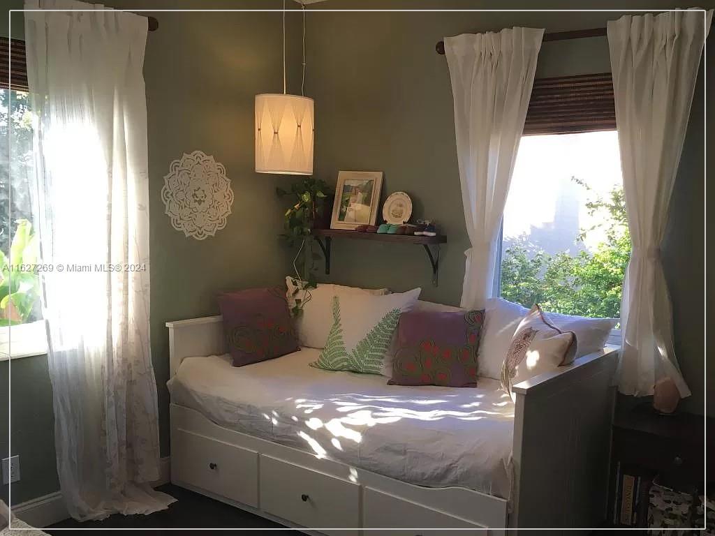 8818 Abbott Avenue Surfside, FL 33154 - Photo 20 of 28 a bed sitting in a bedroom next to a window