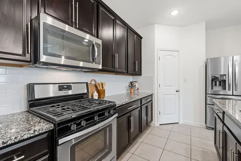 a kitchen with stainless steel appliances granite countertop a stove and a microwave