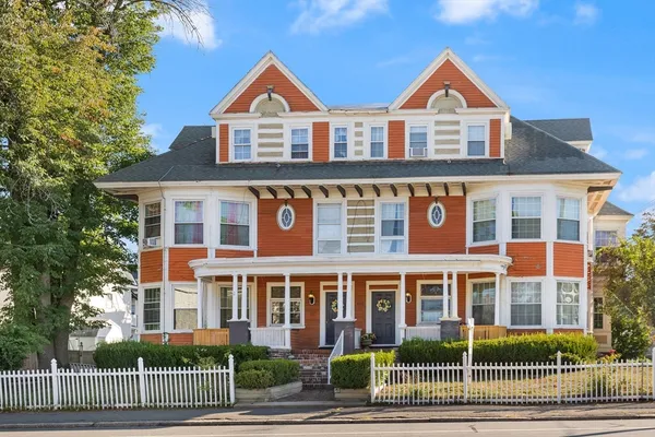 front view of a brick house with a yard