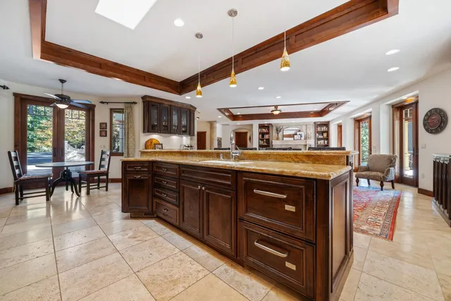 a dining room with wooden floor a chandelier a wooden table and chairs