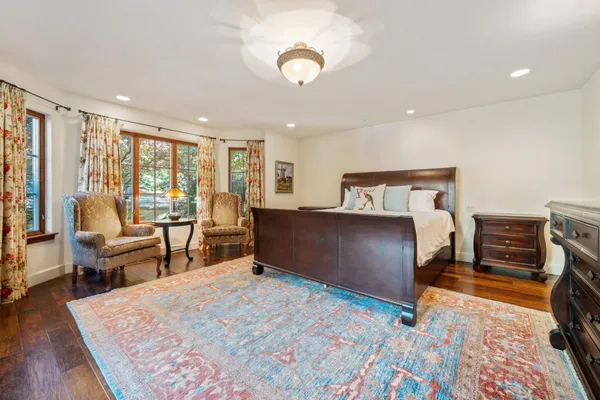 a spacious bedroom with a large bed and a chandelier