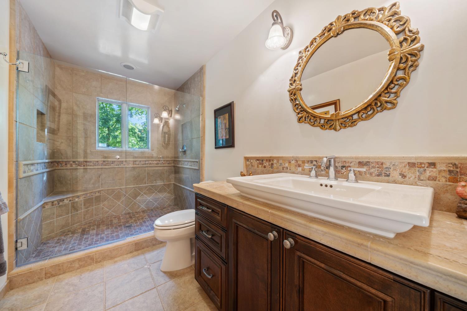 4581 Highway 4 Murphys, CA 95247 - Photo 36 of 65 a bathroom with a granite countertop sink mirror vanity and toilet