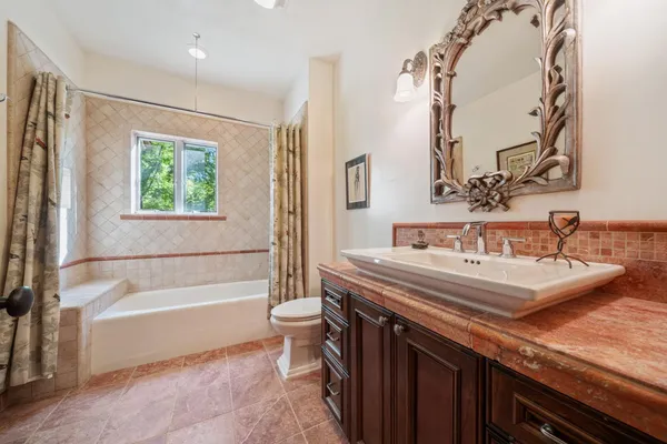 a bathroom with a toilet a sink and mirror