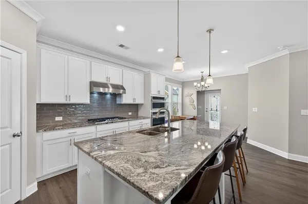 a kitchen with stainless steel appliances granite countertop stove top oven a sink refrigerator and cabinets