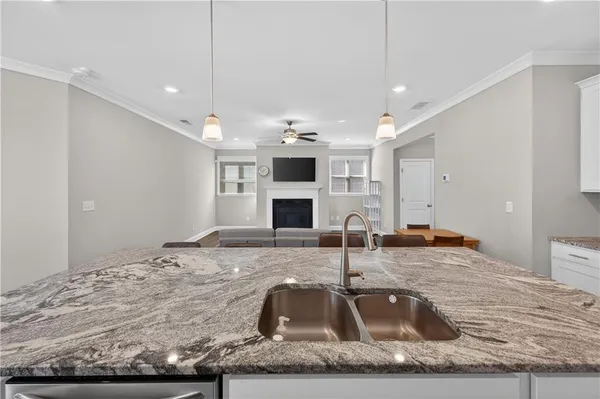 a room with kitchen island a sink and chandelier