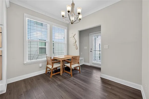 a dining room with wooden floor and a chandelier