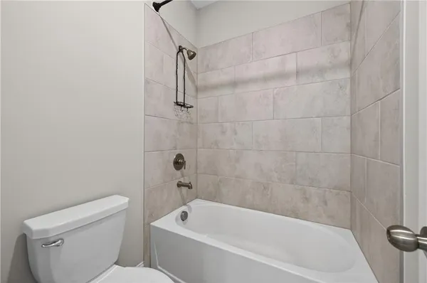 a white bath tub sitting next to a white toilet and a shower