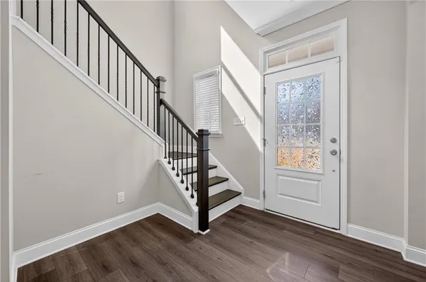 a view of an entryway with wooden floor and door