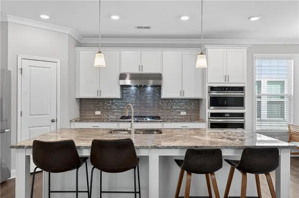 a kitchen with granite countertop a counter top space cabinets and stainless steel appliances