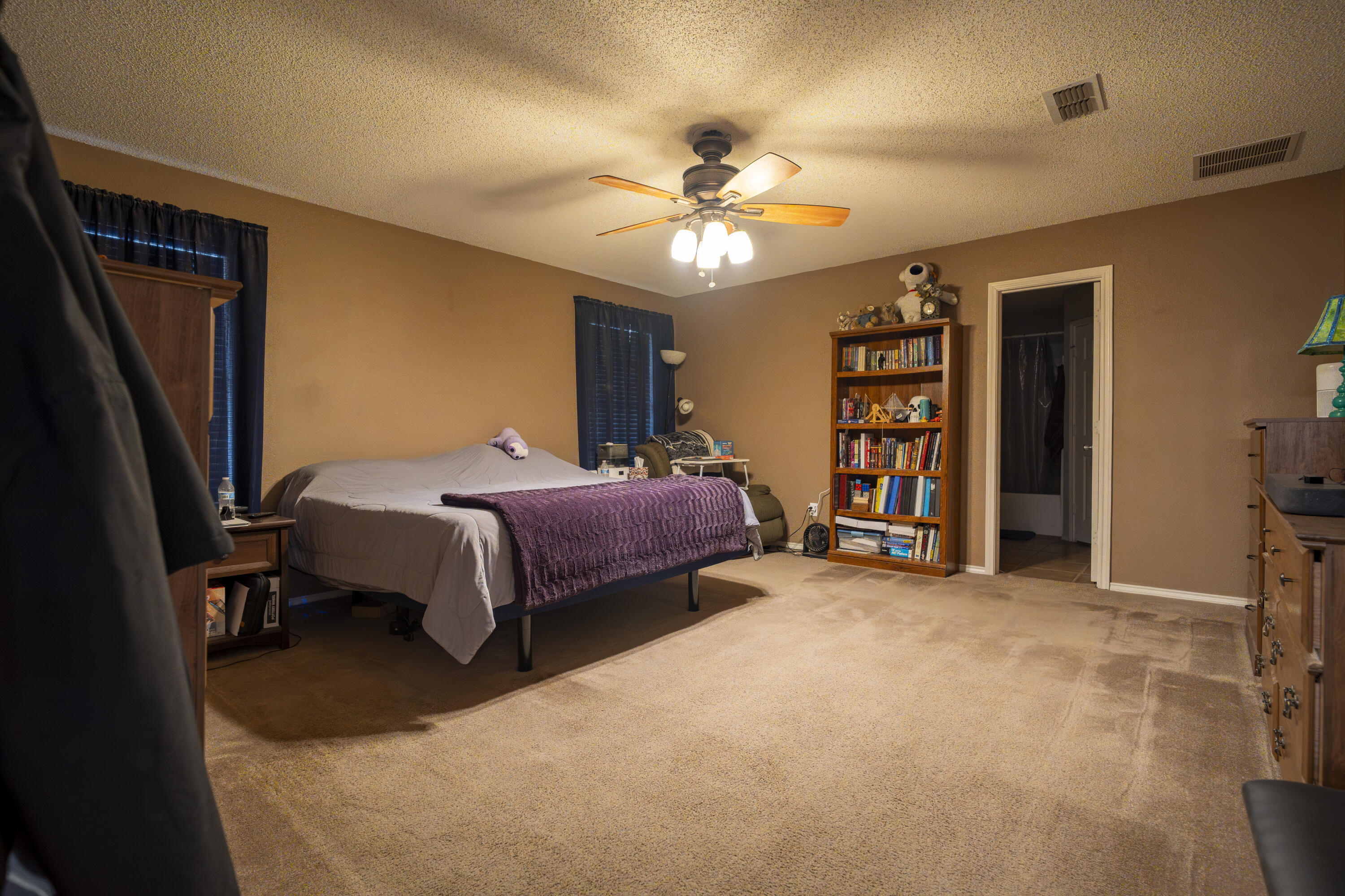 6319 13th Street Lubbock, TX 79416 - Photo 14 of 21 a bedroom with a bed and a chandelier