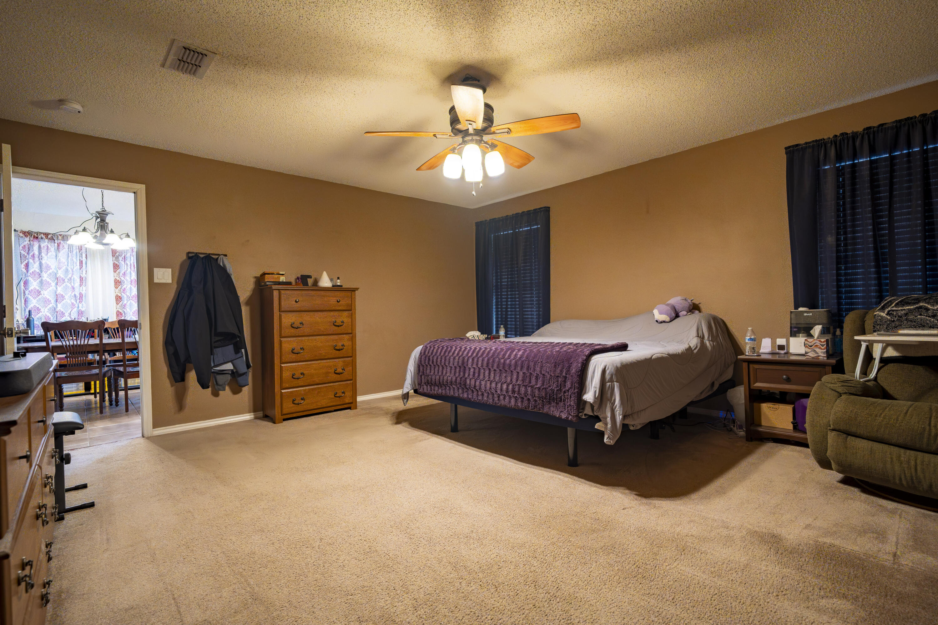 6319 13th Street Lubbock, TX 79416 - Photo 15 of 21 a spacious bedroom with a bed a couch and a chandelier