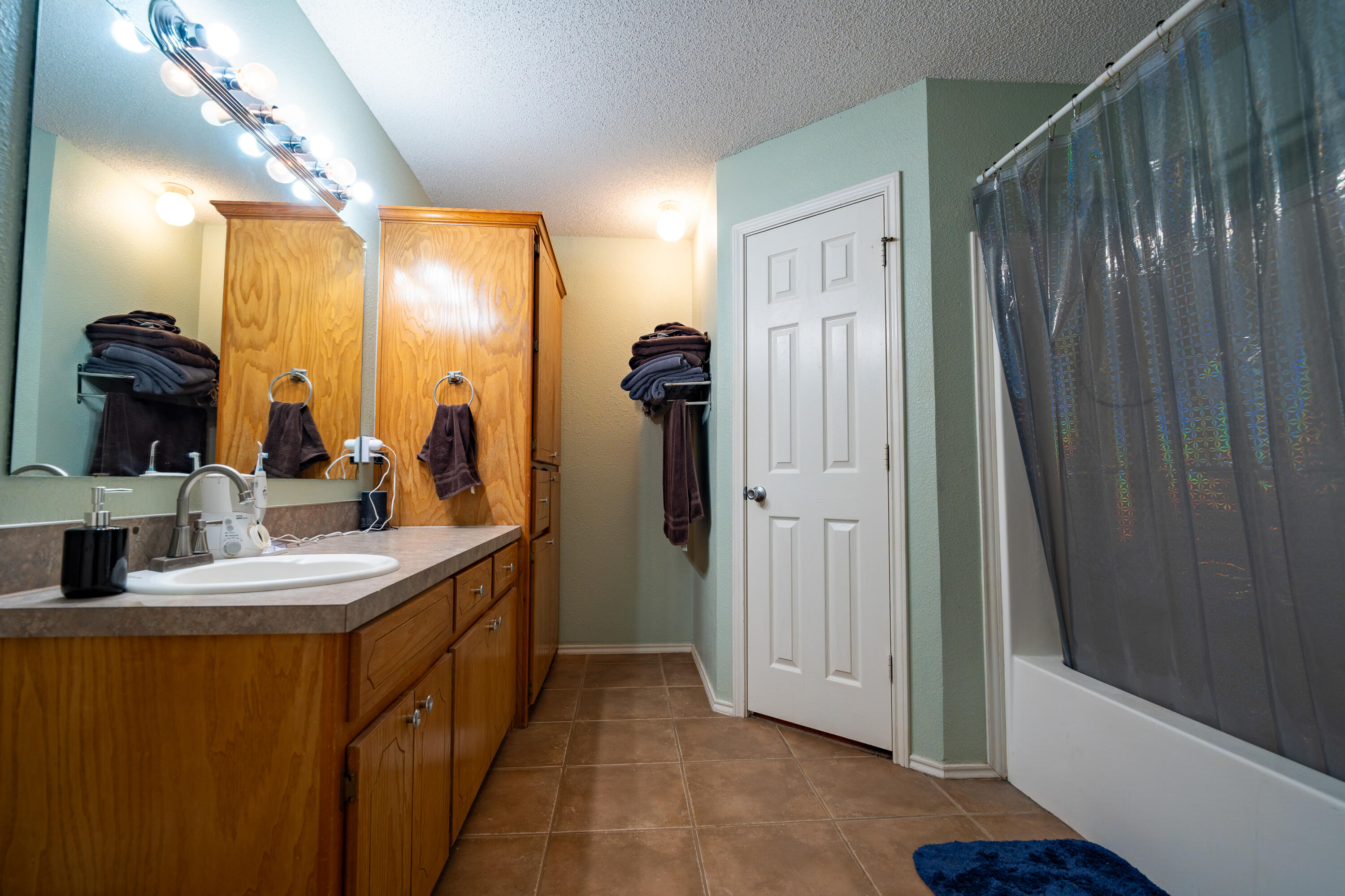 6319 13th Street Lubbock, TX 79416 - Photo 16 of 21 a bathroom with a sink and mirror