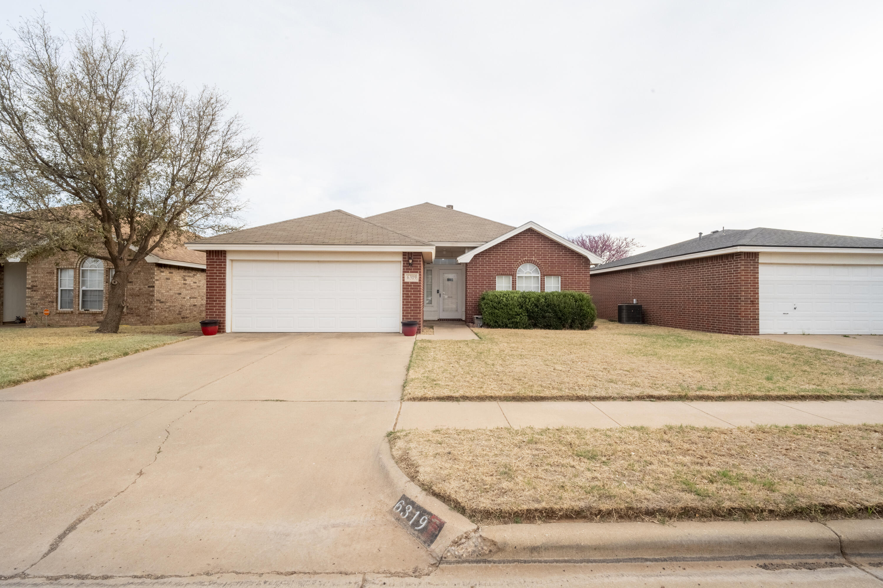 6319 13th Street Lubbock, TX 79416 - Photo 2 of 21 a front view of a house with a yard and garage
