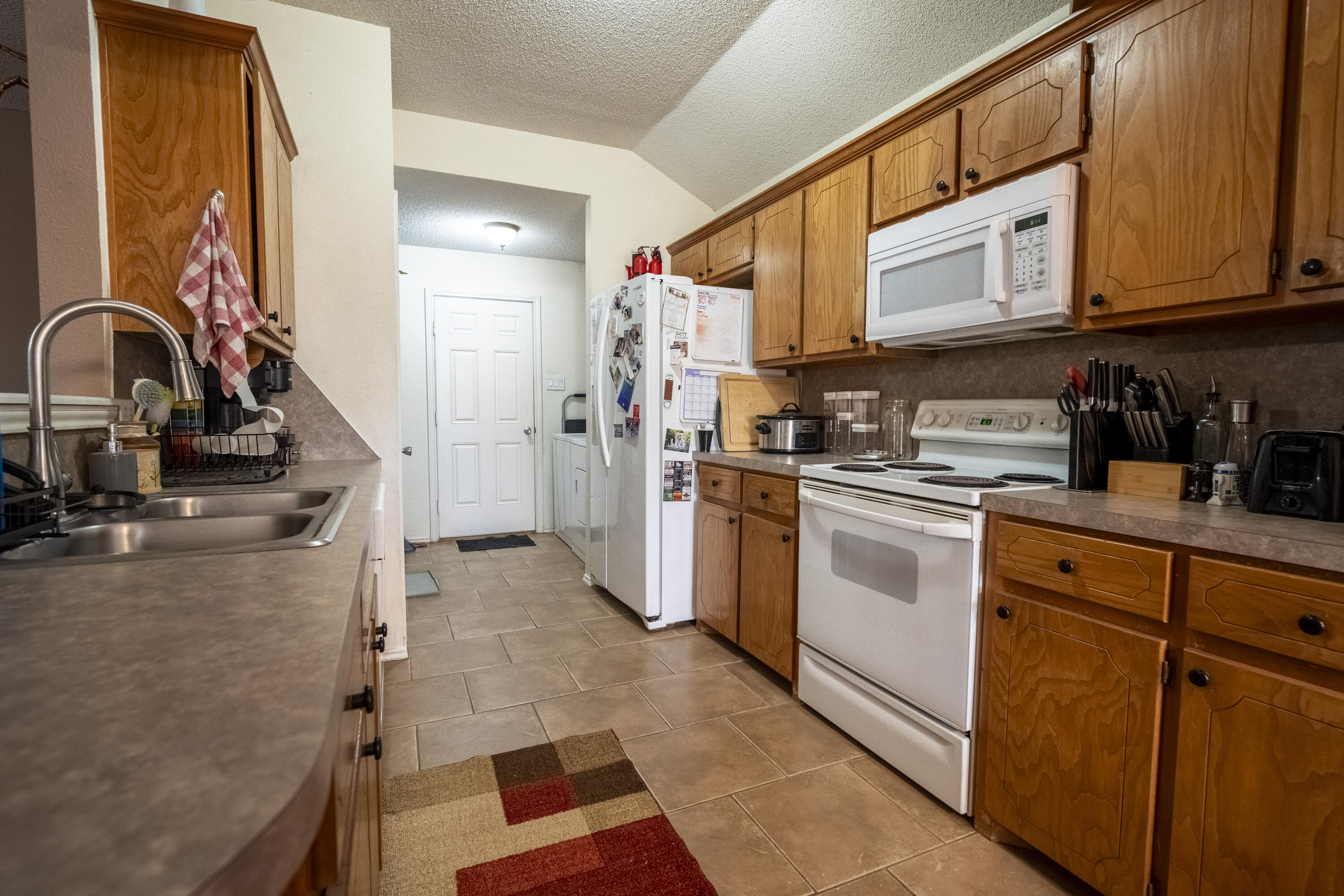 6319 13th Street Lubbock, TX 79416 - Photo 5 of 21 a kitchen with stainless steel appliances granite countertop a sink and cabinets