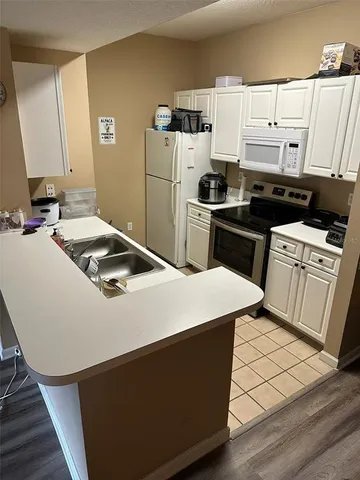 a kitchen with a sink a stove top oven and refrigerator