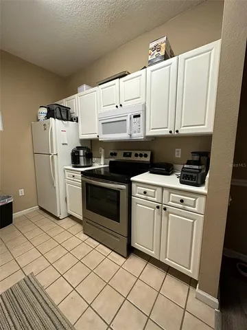 a kitchen with cabinets and white appliances