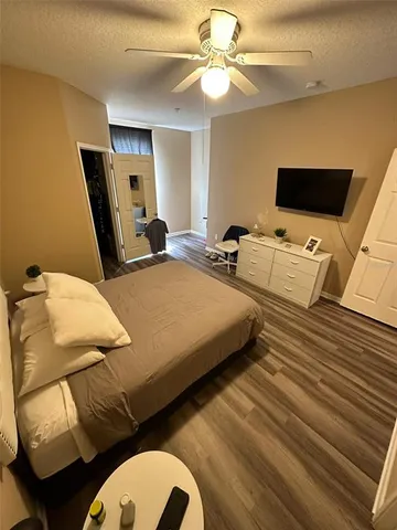 a bedroom with a bed a couch and a flat screen tv