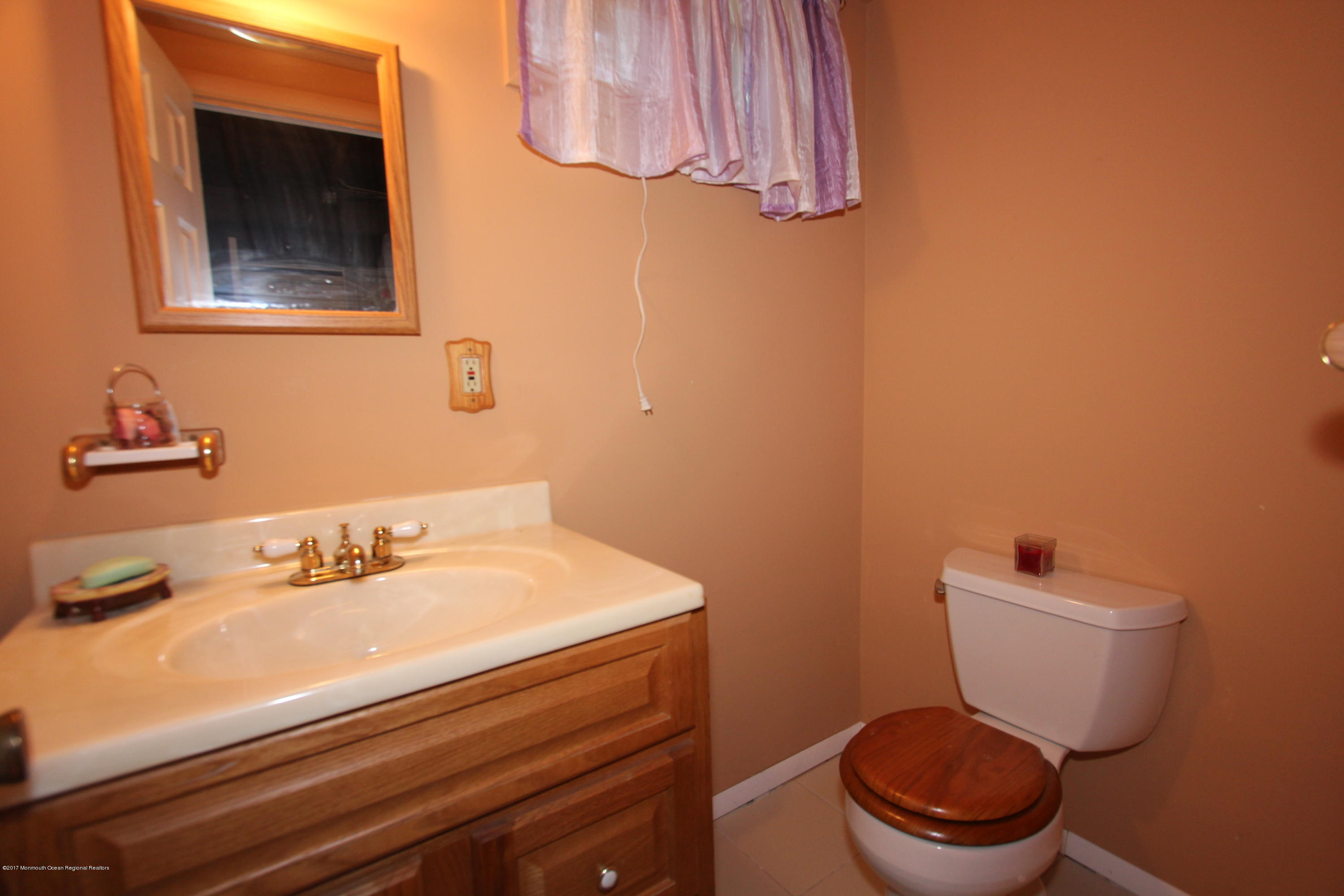 904 Fordham Road Neptune Township, NJ 07753 - Photo 24 of 24 a bathroom with a sink a toilet and a mirror