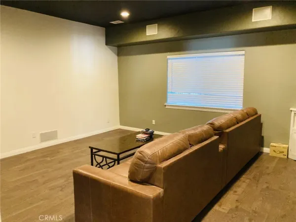 a room with gym equipment on wooden floor and windows