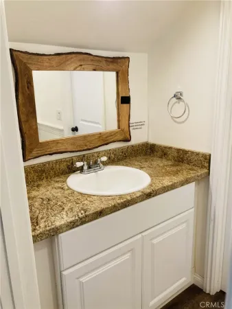 a bathroom with a granite countertop toilet and a sink