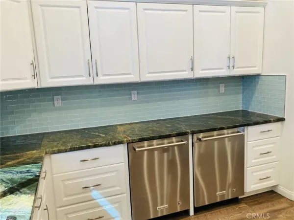 a kitchen with granite countertop white cabinets and a stove