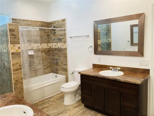 a bathroom with a shower sink vanity and mirror
