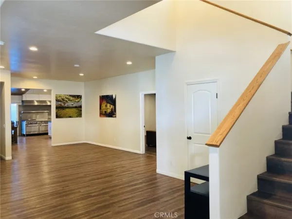 an empty room with wooden floor and a ceiling fan
